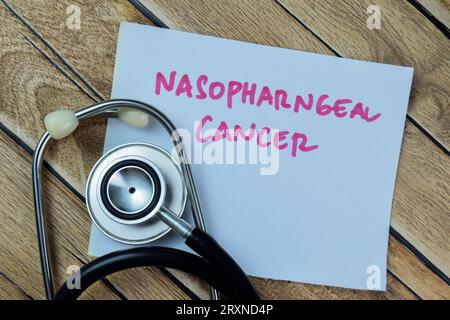 Concetto di cancro nasofarngeo scrivere su note adesive con stetoscopio isolato su un tavolo di legno. Foto Stock