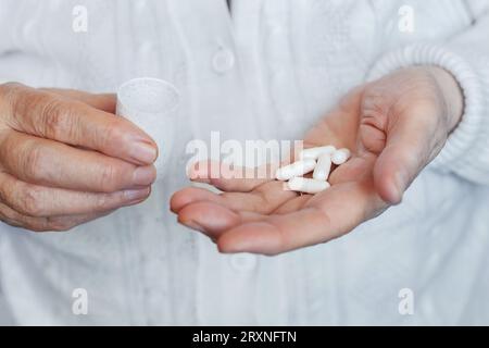 Capsule mediche, pillole nelle mani di una donna anziana, primo piano Foto Stock