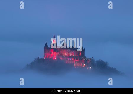 Castello di Hohenzollern con luci natalizie nella nebbia dal Corno Zeller, Hechingen, Alb Svevo, Baden-Wuerttemberg, Germania Foto Stock