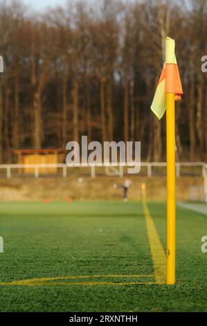 Palo d'angolo di un campo da calcio in erba sintetica con un giocatore di calcio Foto Stock