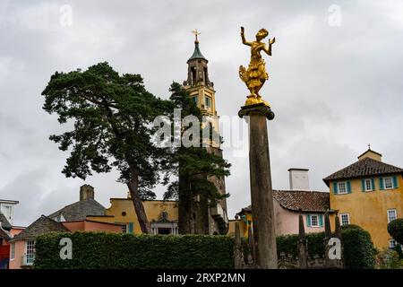 Statua dorata e colorata architettura italiana nel villaggio di Portmeirion, Galles Foto Stock