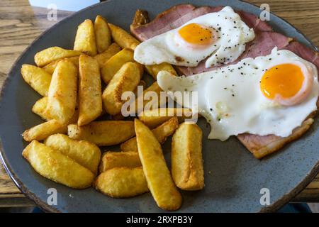 Un tipico pasto inglese da pub a base di prosciutto, uova e patatine fritte. Foto Stock