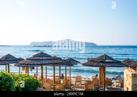 Creta, Chania - file di sdraio e ombrelloni sulla spiaggia sabbiosa Foto Stock