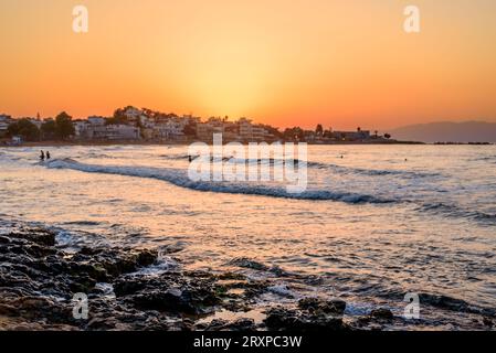 Onde dalla forma favolosa che si infrangono su una spiaggia sabbiosa all'alba a Creta Foto Stock