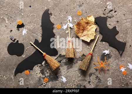 Composizione di Halloween con scope, pipistrelli e fantasmi su sfondo grunge grigio Foto Stock