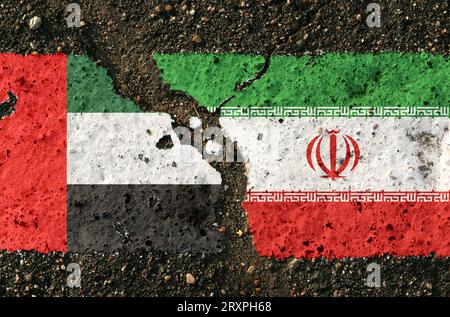 Sul marciapiede, le immagini delle bandiere degli Emirati Arabi Uniti e dell'Iran, come simbolo di confronto. Immagine concettuale. Foto Stock