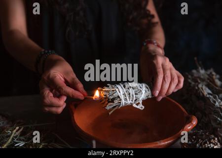 Accendendo un incenso, strega alla vigilia di tutti i santi che esegue un rituale di pulizia, Halloween, credenze spirituali, magia bianca Foto Stock