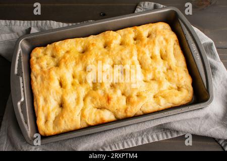 Focaccia appena sfornata in una padella poco profonda: Pane italiano appena sfornato in una padella metallica Foto Stock