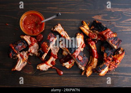Costolette coreane Gochujang Baby Back con salsa su fondo di legno: Costolette di lombato di maiale cotte in salsa barbecue coreana calda e piccante Foto Stock