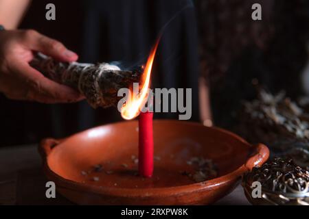 Accendendo un incenso, strega alla vigilia di tutti i santi che esegue un rituale di pulizia, Halloween, credenze spirituali, magia bianca Foto Stock