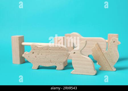 Animali in legno e recinzione su sfondo blu chiaro. Giocattolo per bambini Foto Stock