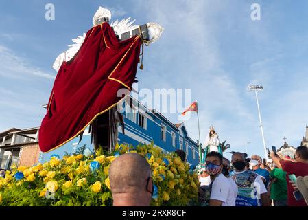 Salvador, Bahia, Brasile - 31 dicembre 2021: Sulla spiaggia si vedono dei fedeli che trasportano il ponteggio con l'immagine di Gesù Cristo, signore dei marinai Foto Stock