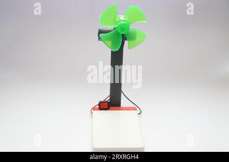 Mini ventilatore realizzato utilizzando semplici componenti elettronici isolati su sfondo bianco. Ventola con elica in plastica e motore CC Foto Stock