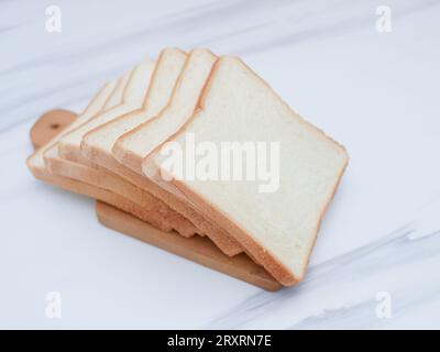 fette di pane bianco sul tagliere di legno Foto Stock