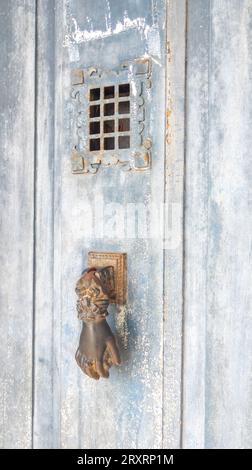 Spioncino incernierato per la porta sulla vecchia facciata in legno Foto Stock