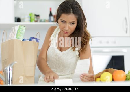la casalinga esamina l'assegno dopo lo shopping Foto Stock