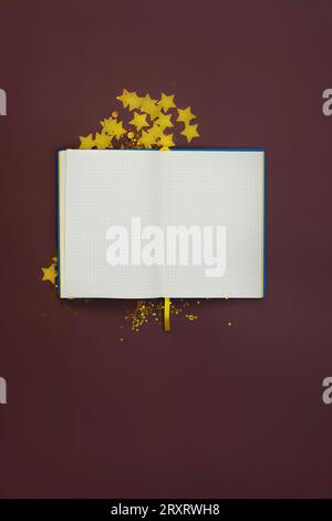 Blocco note con carta bianca e stelle e paillettes dorate per la creatività. Mockup bianco per quaderni Foto Stock