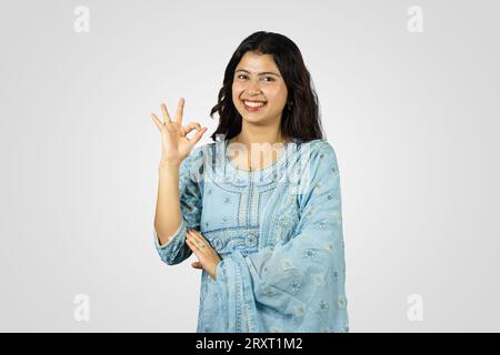 Giovane sorridente Asiatica Nepalese Indiana casalinga dando diversi migliori gesti e pose con saluto Foto Stock