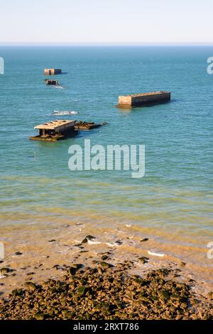 Resti dei cassoni Phoenix utilizzati per costruire il porto artificiale di gelso a Gold Beach ad Arromanches, in Francia, dopo gli sbarchi in Normandia nella seconda guerra mondiale. Foto Stock