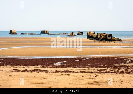 Resti di cassoni Phoenix sulla sabbia, utilizzati per costruire il porto di Mulberry a Gold Beach ad Arromanches, in Francia, dopo gli sbarchi in Normandia nella seconda guerra mondiale. Foto Stock