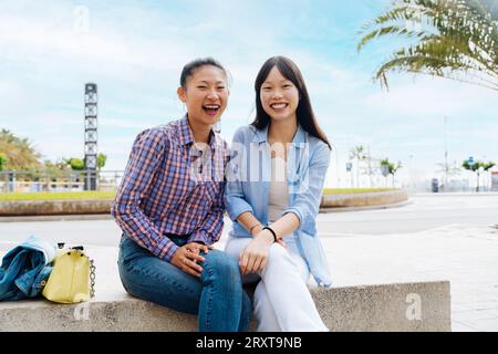 Belle e felici donne cinesi che legano all'aperto in città - giocose belle donne asiatiche adulte che si incontrano e si divertono all'aperto, concetti su Foto Stock