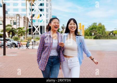 Belle e felici donne cinesi che legano all'aperto in città - giocose belle donne asiatiche adulte che si incontrano e si divertono all'aperto, concetti su Foto Stock