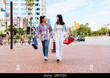 Belle e felici donne cinesi che legano all'aperto in città - giocose belle donne asiatiche adulte che si incontrano e si divertono all'aperto, concetti su Foto Stock