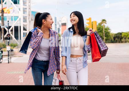 Belle e felici donne cinesi che legano all'aperto in città - giocose belle donne asiatiche adulte che si incontrano e si divertono all'aperto, concetti su Foto Stock