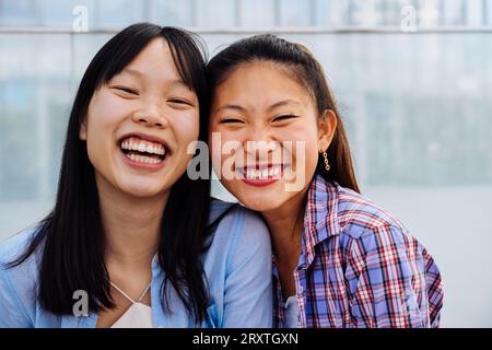 Belle e felici donne cinesi che legano all'aperto in città - giocose belle donne asiatiche adulte che si incontrano e si divertono all'aperto, concetti su Foto Stock