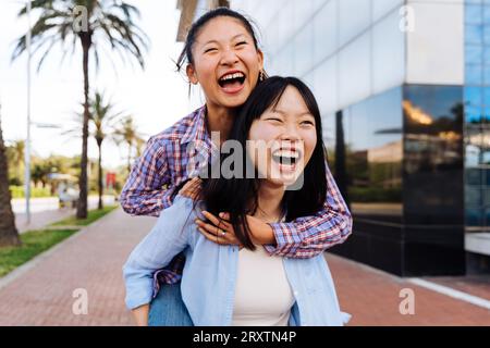 Belle e felici donne cinesi che legano all'aperto in città - giocose belle donne asiatiche adulte che si incontrano e si divertono all'aperto, concetti su Foto Stock