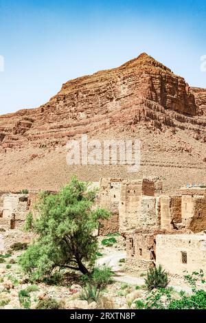 Edifici in mattoni di fango di un antico villaggio con canyon rossi su sfondo, valle di Ziz, montagne dell'Atlante, Marocco, Nord Africa, Africa Foto Stock