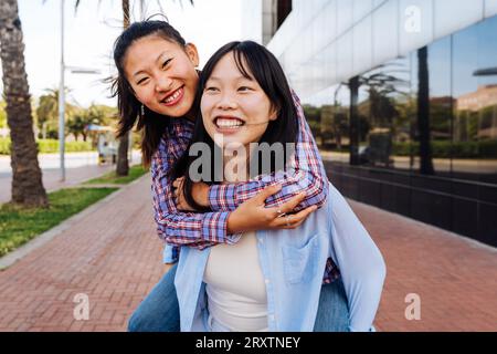 Belle e felici donne cinesi che legano all'aperto in città - giocose belle donne asiatiche adulte che si incontrano e si divertono all'aperto, concetti su Foto Stock