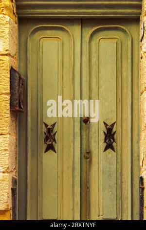 Tradizionali battitori di porte in ottone con design a croce maltese all'esterno di un edificio nei vicoli della città vecchia di Birgu (città Vittoriosa), Malta Foto Stock