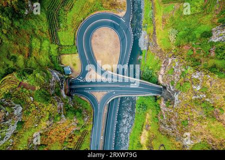 Splendida vista a volo d'uccello dell'uscita di una superstrada situata tra due portali di tunnel, Ribeira da Janela, Madeira, Portogallo Foto Stock