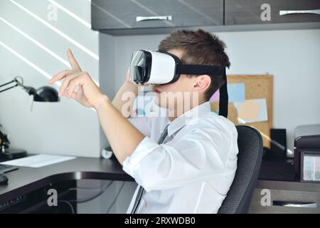 Commerciante che utilizza cuffie per realtà virtuale. Concetto di lavoro aziendale interattivo. Foto Stock