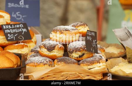 Panini di lievito dolci pieni di semi di papavero e cosparsi di zucchero a velo in vendita presso lo stand della panetteria presso il mercato agricolo Foto Stock