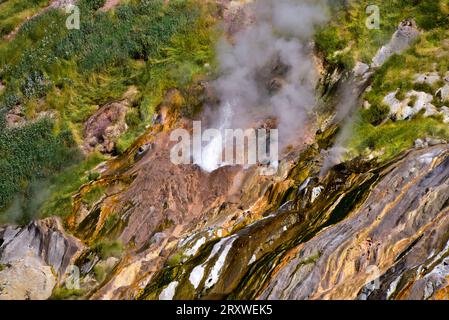 Getti d'acqua calda da un geyser nella Valle dei geyser nella riserva naturale di Kronotsky, sito patrimonio dell'umanità dell'UNESCO a Kamchatka, nell'Estremo Oriente russo Foto Stock