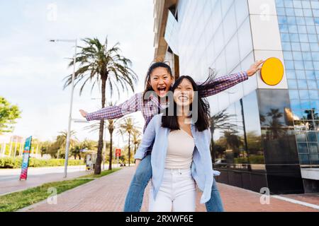 Belle e felici donne cinesi che legano all'aperto in città - giocose belle donne asiatiche adulte che si incontrano e si divertono all'aperto, concetti su Foto Stock