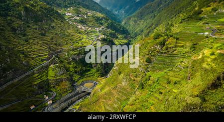 Vista panoramica e bella dall'alto del piccolo villaggio di montagna di Ribeira da Janela a Madeira, Portogallo, che si estende lungo una montagna Foto Stock