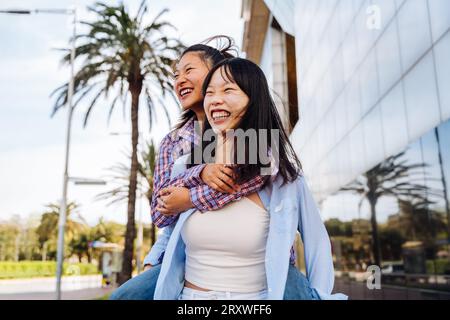 Belle e felici donne cinesi che legano all'aperto in città - giocose belle donne asiatiche adulte che si incontrano e si divertono all'aperto, concetti su Foto Stock