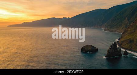 Vista aerea panoramica dell'Oceano Atlantico che si schianta contro la costa e sull'isola rocciosa Ilheus da Rib al largo di Ribeira da Janela a Madeira, Portogallo Foto Stock