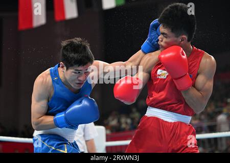 (230927) -- HANGZHOU, 27 settembre 2023 (Xinhua) -- Wang Xiangyang della Cina (blu) compete contro Mark Ashley Fajardo delle Filippine durante il turno preliminare di boxe maschile di 57-63 kg tra Cina e Filippine ai 19 Giochi asiatici di Hangzhou, nella provincia dello Zhejiang della Cina orientale, 27 settembre 2023. (Xinhua/Zhan Yan) Foto Stock