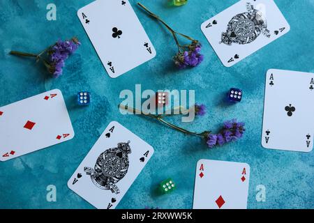 modello con carte da gioco, dadi colorati e fiori statici asciutti su sfondo blu acquerello Foto Stock