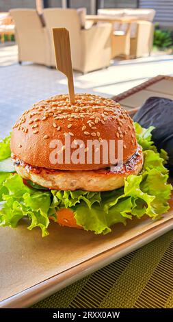 Hamburger fresco alla griglia con polpettine di manzo, pomodori, formaggio, cetriolo e lattuga. Copia spazio Foto Stock