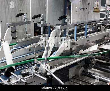 Produzione di incollatrice automatica per cartoni o imballaggi. Settore della stampa Foto Stock