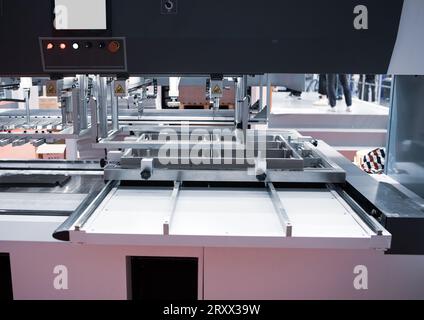 Macchina di chiusura per imballaggio e stripping. Macchina per fustellatura. Foto Stock