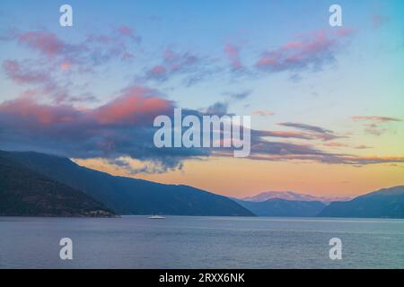 La piacevole città fiorda di Balestrand, Norvegia, situata sul Sognefjord, è una piccola città turistica, qui raffigurata al tramonto. Vista sul fioretto Foto Stock