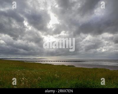 L'estuario del Severn a Severn Beach, Gloucestershire, Regno Unito, si affaccia sul Galles del Sud in una giornata nuvolosa Foto Stock