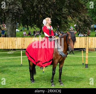 Donna in abito rosso a cavallo che partecipa come regina alla giostra, Lincoln Castle, Lincoln City, Lincolnshire, Inghilterra, REGNO UNITO Foto Stock