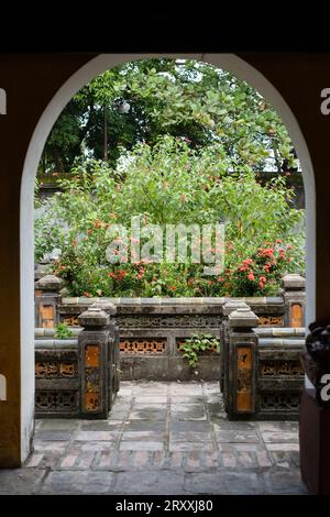 Vista attraverso un arco nel giardino di piacere nella residenza della regina madre imperiale, città imperiale di Huế, Vietnam Foto Stock